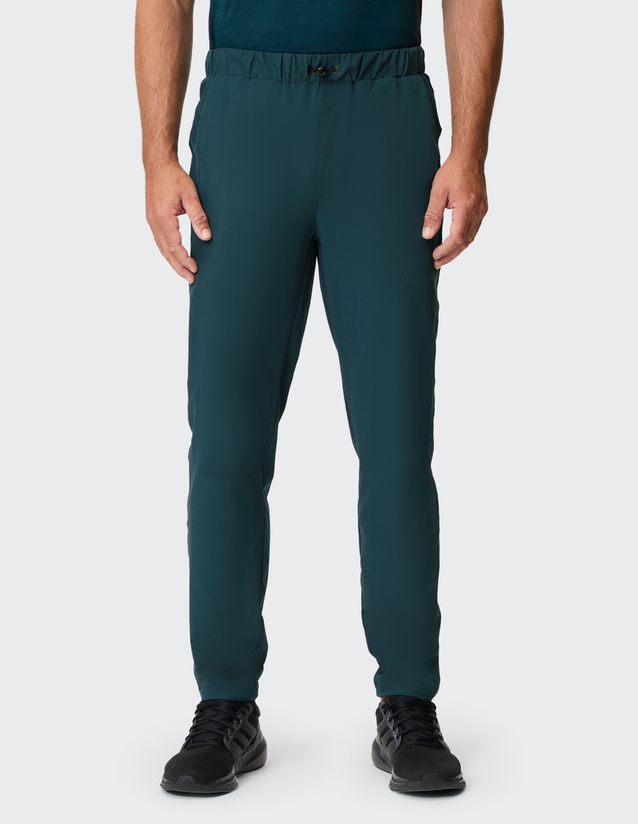 Mann trägt dunkelgrüne Freizeithose mit elastischem Kordelzug in der Taille.